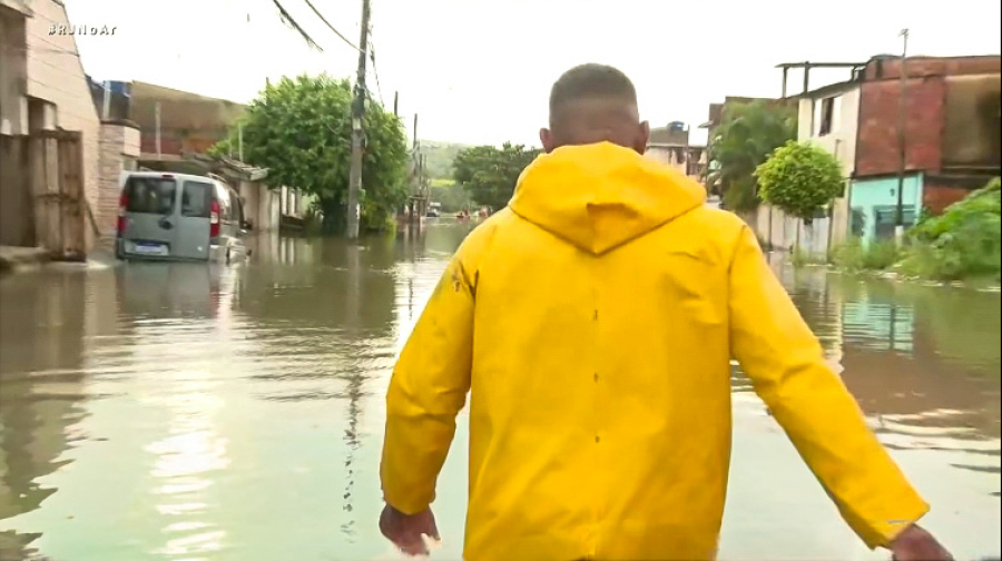 Chuva intensa alaga Guaratiba, na zona oeste do Rio, e voluntário usa bote para resgatar moradores